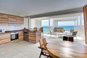 eine Küche mit einem Tisch und Meerblick in der Unterkunft Luxury waterfront villa with swimming pool MQFR08 in Le François