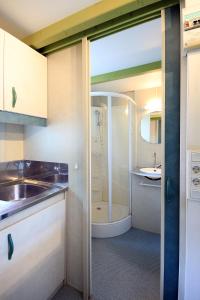 uma pequena casa de banho com um chuveiro e um lavatório. em Camping La Rueda em Cubelles