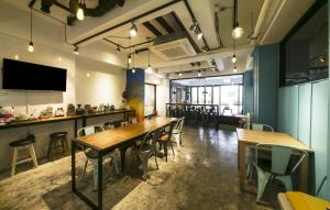 a dining room with tables and chairs and a tv at Backpackers In Yeosu in Yeosu