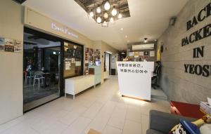 un restaurante con una tienda con un cartel en la pared en Backpackers In Yeosu en Yeosu
