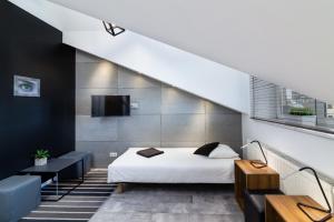 an attic bedroom with a bed and a staircase at Rainbow Apartments 1 in Kraków