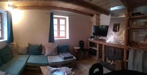 sala de estar con sofá y TV en Le Ptit Chalet, en Valloire