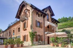 阿爾巴的住宿－Villa La Favorita，前面有盆栽植物的大砖砌建筑