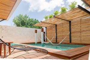a swimming pool with a swing in a house at La Galuna Bacalar in Bacalar