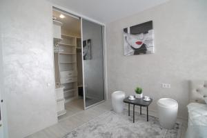 ein Bad mit einer Dusche und einem Tisch in einem Zimmer in der Unterkunft Ніжність in Riwne