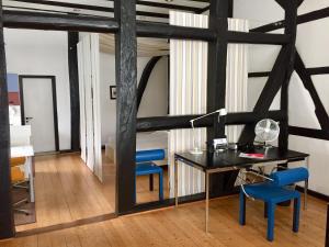 a room with a desk and blue chairs at Suite „Friesland“ - wunderschönes Apartment in Fachwerkhaus in Hannover +25 photos