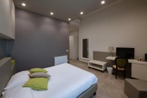 Schlafzimmer mit einem großen weißen Bett und einem Schreibtisch in der Unterkunft B&B Palazzo Paciotti in Trani