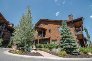 a apartment building with two trees in front of it at Juniper Landing by Lespri Management in Park City