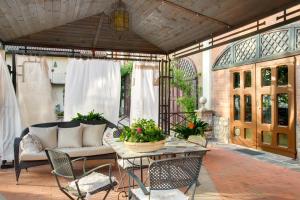 un patio al aire libre con mesa y sillas en Villa La Favorita en Alba
