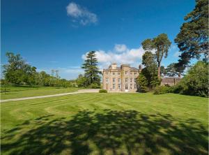 duży dom na trawiastym polu z drzewem w obiekcie Newcourt Manor w mieście Hereford