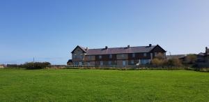 uma casa grande com um campo verde em frente em Coastguards Cottage em Whitby