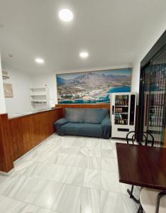 sala de estar con sofá azul y mesa en HOSTAL EL MOLINO, en Marbella
