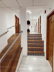 a hallway of an office with a staircase with brown tiles at HOSTAL EL MOLINO in Marbella