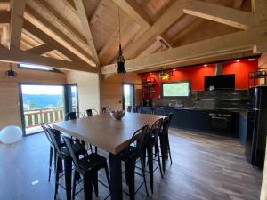 un comedor con una gran mesa de madera y sillas en L'ADRET DU TEMPS CHALET 10 PERSONNES 170m2 en Gérardmer