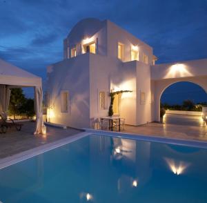 a villa with a swimming pool at night at Meli Meli in Imerovigli