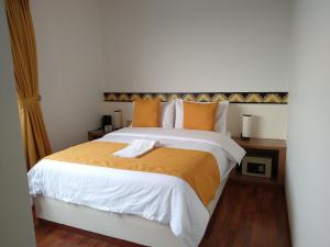1 dormitorio con 1 cama grande con sábanas de color naranja y blanco en Hotel SJ, en Mosquera