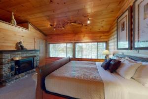 a bedroom with a bed and a fireplace in a cabin at Making Memories in Mariaville in Otis