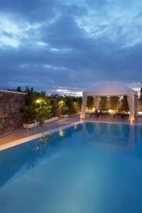 a swimming pool at night with a gazebo at Meli Meli in Imerovigli