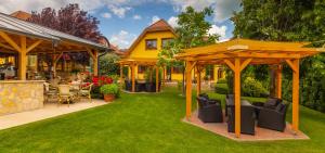 a backyard with a gazebo and chairs and tables at Hotel Mayer Alsóörs in Alsóörs