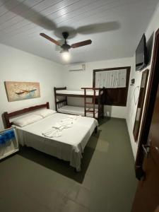 1 dormitorio con 1 cama y ventilador de techo en Pousada Maanaim, en Ubatuba