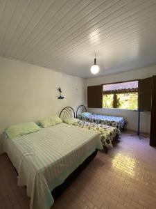 a bedroom with two beds and a window at Rancho Manacá in Guaramiranga