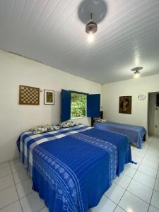 a bedroom with two beds with blue comforters at Rancho Manacá in Guaramiranga