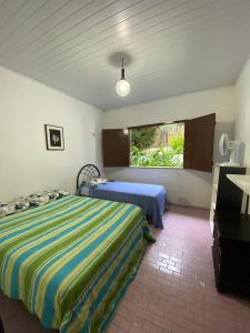 a bedroom with two beds and a window at Rancho Manacá in Guaramiranga