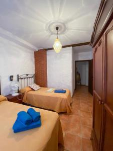 a room with two beds with blue towels on them at El Antiguo Molino in El Bosque