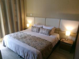 a bedroom with a large white bed with two pillows at Hotel Salento Plaza in Salento