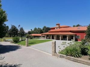 ein rotes Gebäude mit einem Weg davor in der Unterkunft Villam Natura & Spa in Vila Nova de Famalicão