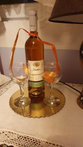 a bottle of alcohol and two glasses on a table at Apartman" Ruža" in Višegrad