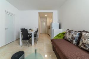 ein Wohnzimmer mit einem Sofa und einem Tisch in der Unterkunft Java Apartments in Dobrota