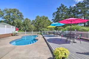 eine Terrasse mit einem Tisch, einem Sonnenschirm und einem Pool in der Unterkunft Cozy Ironton Cabin with Shared Pool and Private Patio! in Ironton