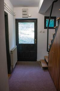 a hallway with a black door and a window at Green door 2 in Vrnjačka Banja