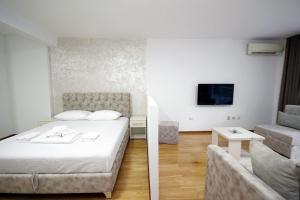 ein Hotelzimmer mit einem Bett und einem Sofa in der Unterkunft Holiday apartments Petrovac in Petrovac na Moru
