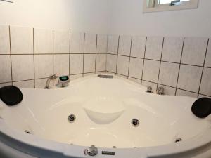 een bad in een kamer met een betegelde muur bij 8 person holiday home in Hadsund in Hadsund