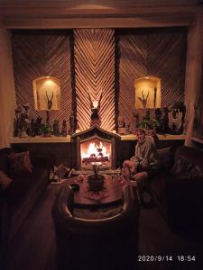 a man sitting on a couch in front of a fireplace at DWan Tea Mountain Side in Jatiluwih