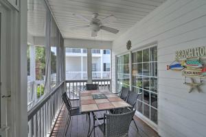 a porch with a table and chairs and a ceiling fan at Surfside Beach Home Base Steps to Pool and Ocean! in Myrtle Beach