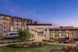 a building with two cars parked in a parking lot at Crowne Plaza Milwaukee South by IHG in Milwaukee
