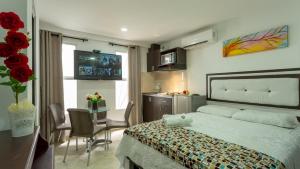 a bedroom with a bed and a table with chairs at Hollywood Beach Suite in Cartagena de Indias