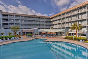 a hotel with a large swimming pool in front of a building at Walk to Beach Nautical Hilton Head Resort Condo! in Hilton Head Island