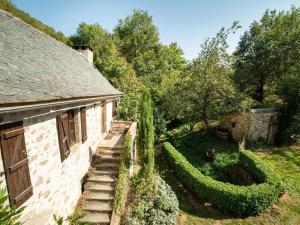 an old stone house with a garden next to it at Sunny water mill with heated swimming pool in Brandonnet