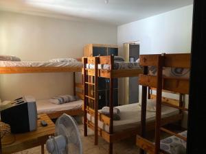 a room with three bunk beds and a fan at Pousada Serra Carioca Friburgo in Nova Friburgo