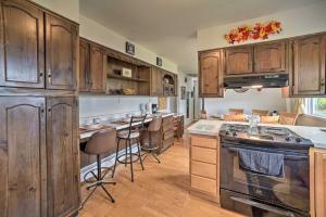 a kitchen with wooden cabinets and an island with bar stools at Albany Home with Fenced Yard and Patio - Pets Welcome! in Albany +16 photos