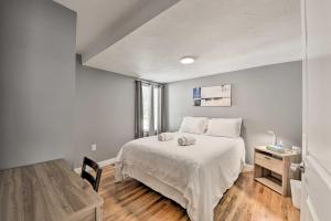 ein Schlafzimmer mit einem großen weißen Bett und einem Tisch in der Unterkunft Renovated Boston Apt - Walk to Downtown Transit! in Boston + 16 Fotos