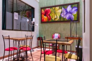 a room with tables and chairs and a painting on the wall at Ayenda 1140 Roma Plaza in Manizales