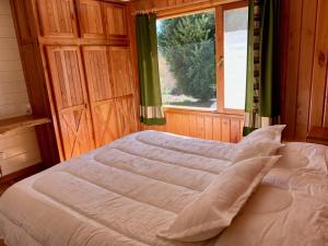 a bedroom with a large bed with a window at Fly Fishing Cabin, Great Views in Junín de los Andes