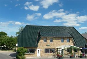 a house with a green roof at Gasthof Lafrenz in Hamdorf