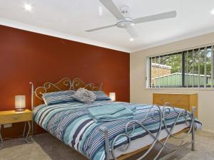 um quarto com uma cama e uma ventoinha de tecto em Saltwater em Callala Beach