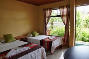 Un pat sau paturi într-o cameră la Hotel Heliconia Los Chiles